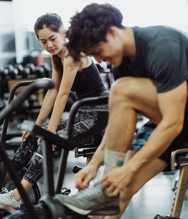 Man performing a dynamic cardio exercise in a modern gym.